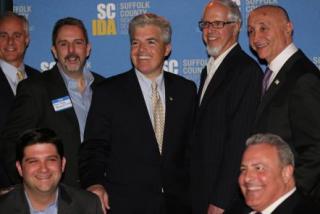 Grant Hendricks, vice chair of the Suffolk IDA, Tyler Roye of Egifter, Suffolk County Executive Steve Bellone, Peter Goldsmith, president of LISTnet, and Tony Giardano, Suffolk IDA board member. Seated in front: Anthony Manetta and Steve Rossetti